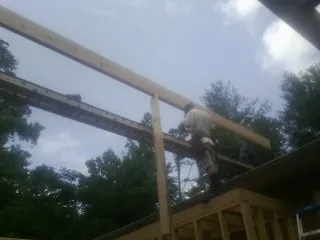 Carpenter setting a ridge beam over a new addition frame — Ice Dam Removal by Roofing Brothers in Callicoon Center