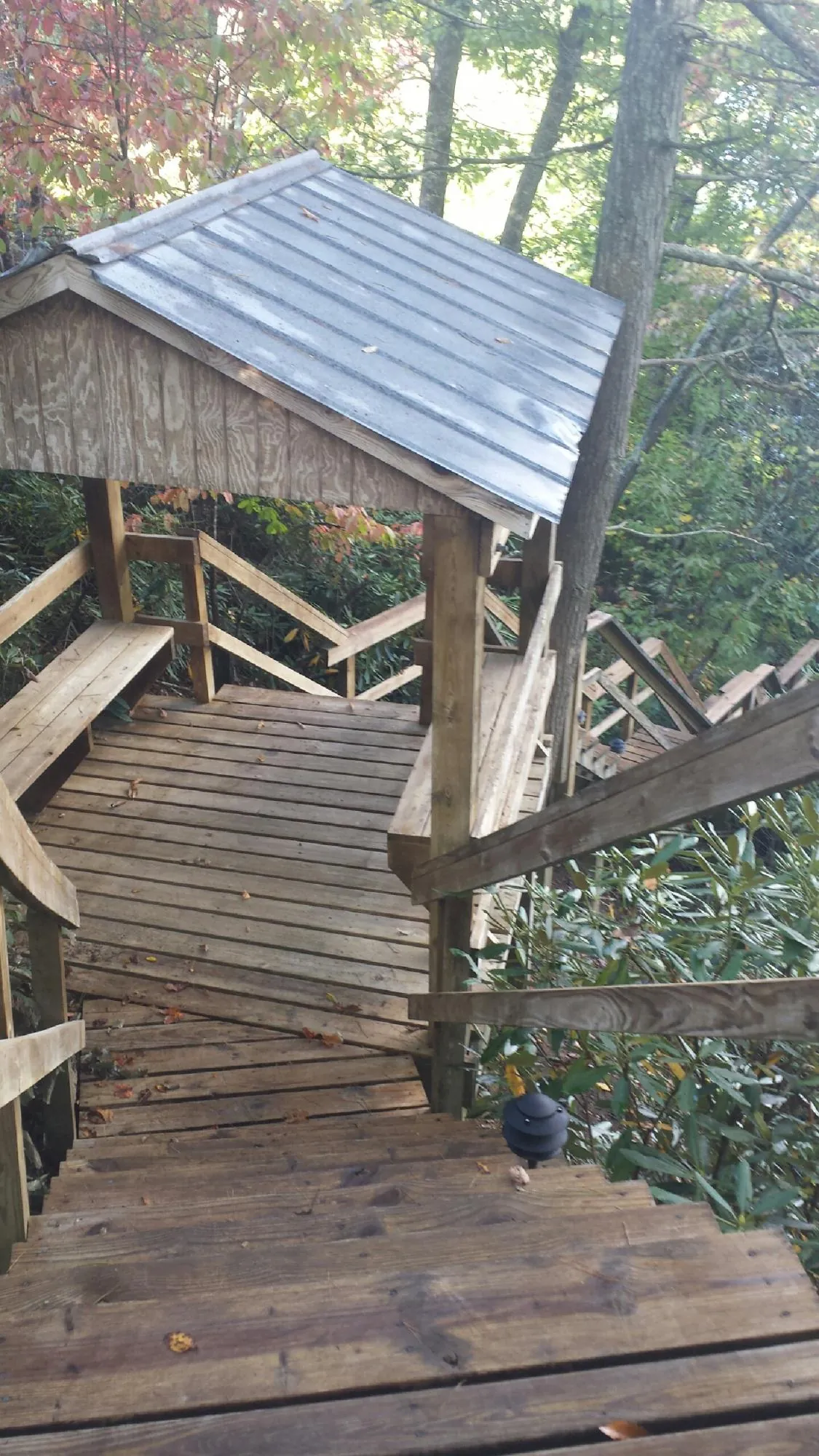 Metal roofed shelter over wooden steps on a wooded walkway — Skylight Repair & Installation work by our crew in Callicoon Center