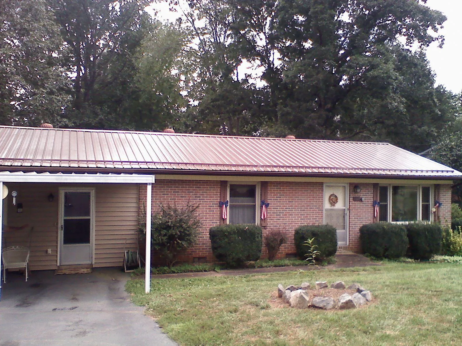 Bronze metal roof and carport on a brick ranch home — Roof Repair work by our crew in Callicoon Center